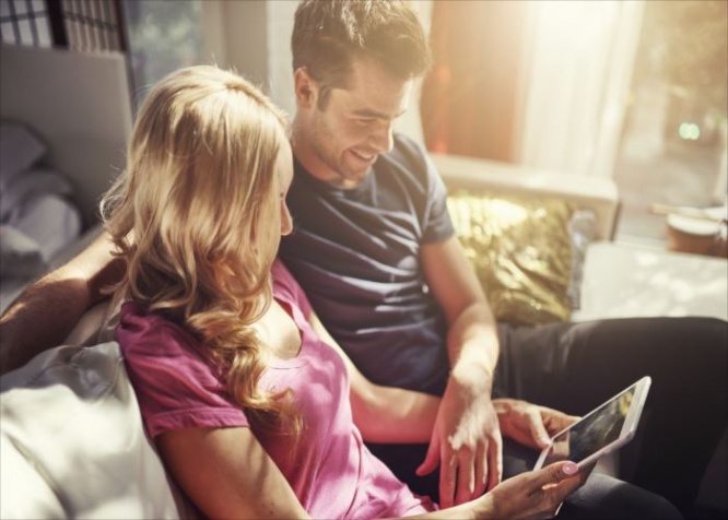 attractive couple using tablet together o nfuton h at home