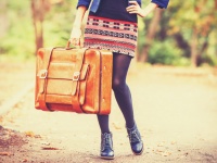 girl with suitcase at autumn outdoor.