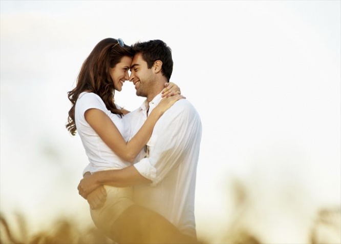 Loving young couple embracing in a corn field together - copyspace