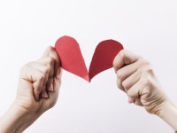 Woman hands tearing red paper heart