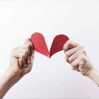 Woman hands tearing red paper heart