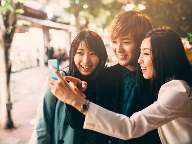 Happy japanese friends surfing the net