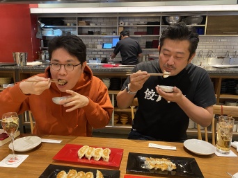 美味しそうに餃子を食べる蜂須賀敬明さん（左）と小野寺力さん