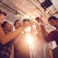 Low angle view of happy start up team toasting with wine while celebrating their business achievement.