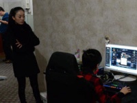 母親に見守られながらオンラインゲームをする少年。