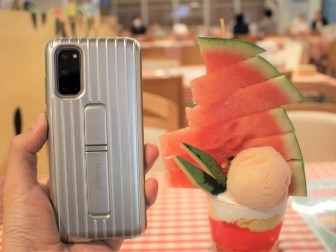筆者のスマートフォンと積み上げられたスイカを比較