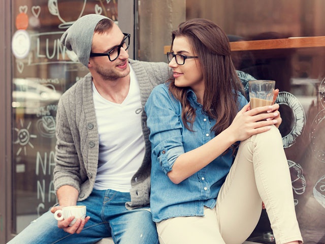 Young people relaxing with cup of coffee outside the cafe