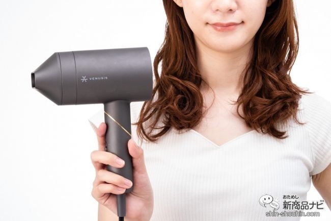 胸の前に『 VENUSiS 遠赤イオンドライヤー　VDC-5000 』 を持つ女性