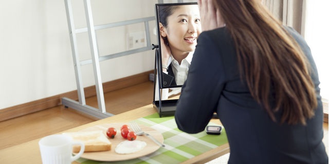 朝食と鏡を見る女性