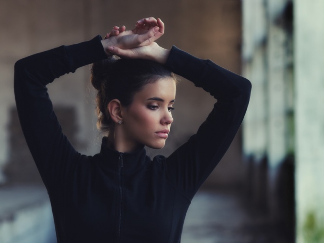 Beautiful girl stretching before crossfit workout in abandoned b