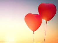 two red balloons in shape of heart on the background of sunset sky. the concept of love and Valentine's day.