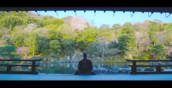 天龍寺・曹源池庭園を前に座禅を組む薬師寺さん（画像提供：iroha records キッサコ）