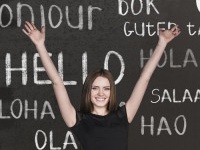 Woman near words hello in different languages on chalkboard