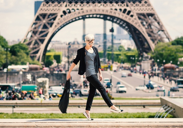 Fashion young blonde woman walking in front of the Eiffel Tower