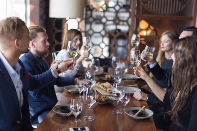 Group of friends toasting with white wine in restaurant