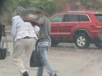 土砂降りの中、自らのコートを傘代わりに女性の頭にかけ、目的地へエスコートした少年の姿を警官が目撃。感動のシェア