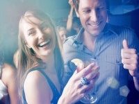 Group of young boys and girls dancing while enjoying at pub