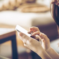 Young happy woman  typing on smart phone