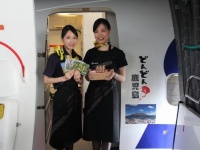 「どんどん鹿児島」のステッカーとCAが乗客をお迎え