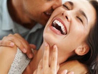 Closeup of beautiful young couple embracing and laughing