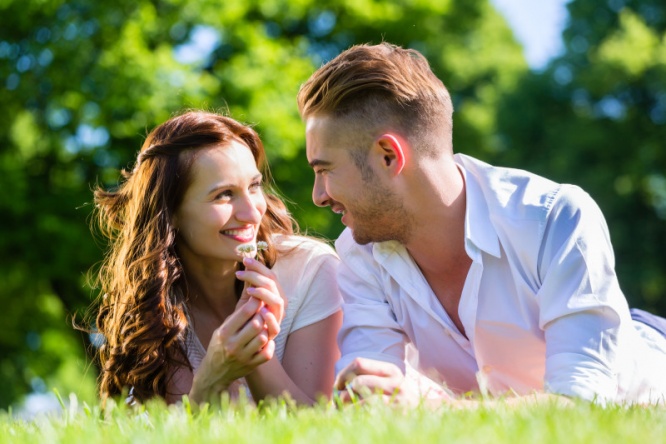 Couple laying on park lawn enjoying sun