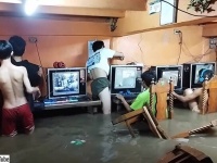 台風で洪水発生、水浸しになりながらネットカフェでゲームをプレイし続けるフィリピンの子供たち