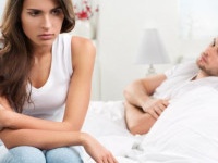 Portrait of unhappy young heterosexual couple in bedroom