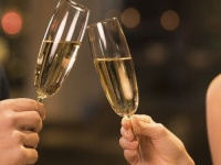 Couple toasting champagne glasses in a luxury restaurant. Couple enjoying meal and drinks in a restaurant. Young loving couple celebrating their anniversary, new year.