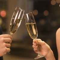 Couple toasting champagne glasses in a luxury restaurant. Couple enjoying meal and drinks in a restaurant. Young loving couple celebrating their anniversary, new year.