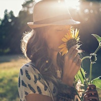 Girl smells sunflower in nature