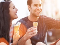 romantic couple eating ice cream at park