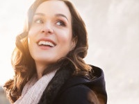 Closeup of smiling thinking woman looking away outdoor