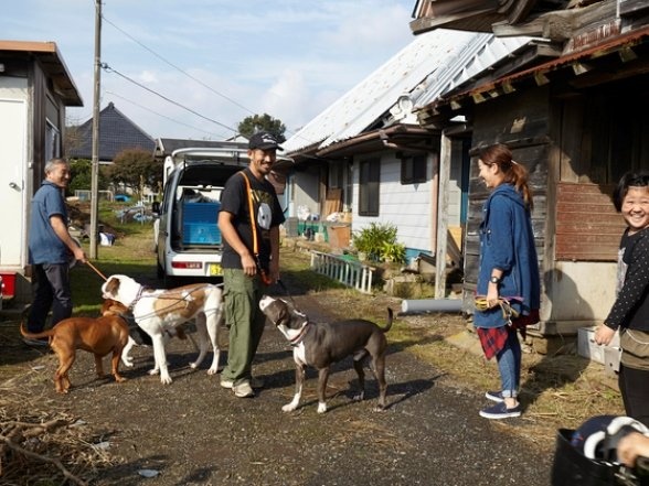 勝浦の古民家の前で犬の世話をする池田さん（画像提供：WAMPERS）