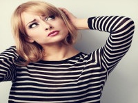 Annoyed unhappy thinking young woman looking up. Toned color portrait