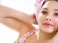 Young girl front of mirror in bathroom putting cream on her face