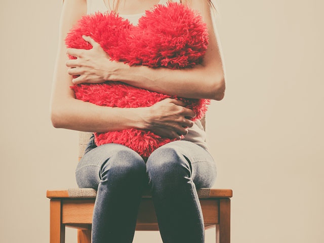 クッションを抱きしめる女性