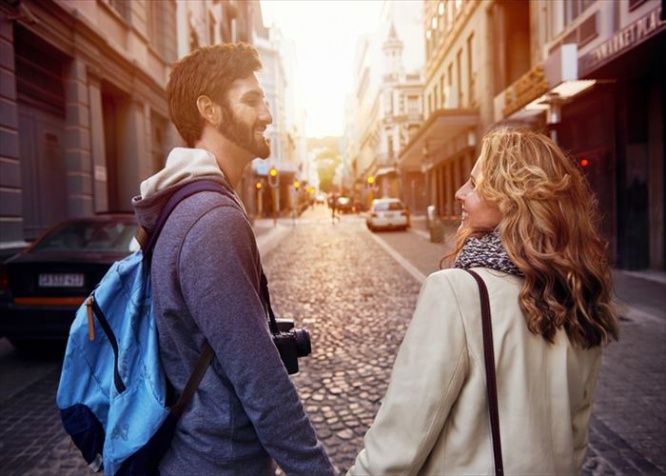 Happy young tourist couple walking street on vacation together