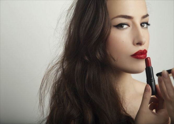 beautiful young woman apply red lipstick, studio shot