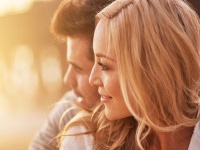 pretty girl cuddling with boyfriend on beach at santa monica