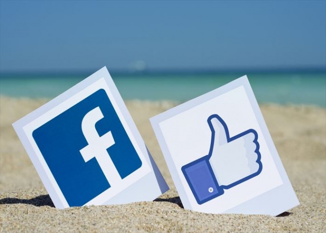 KIEV, UKRAINE - AUGUST 10, 2015: Facebook like logos for e-business, web sites, mobile applications, banners, printed on paper and placed in the sand against the sea Social network facebook sign.