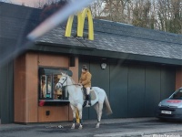 1馬力でもご利用できます。馬に乗った女性がマクドナルドのドライブスルーに並ぶ