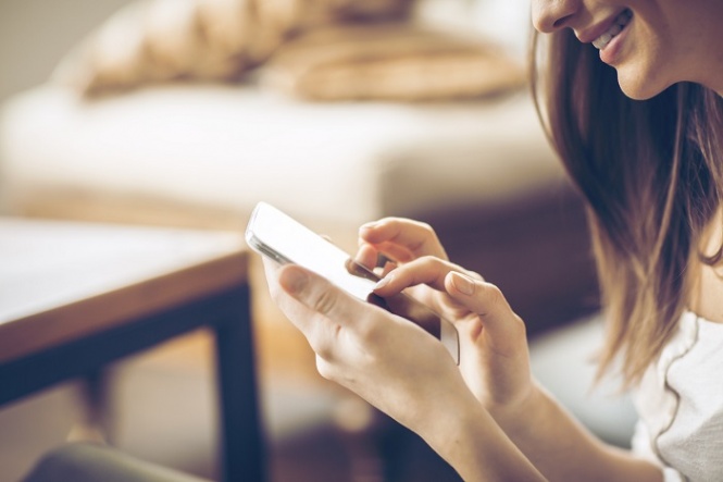 Young happy woman  typing on smart phone