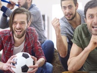 Football fans watching match at home