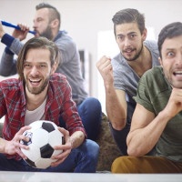 Football fans watching match at home