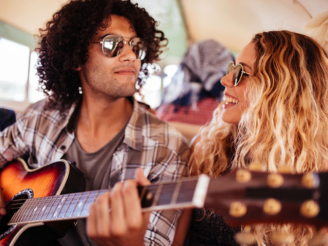 Multi-Racial Hipster friends Singing Together on road trip with guitar