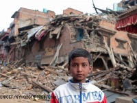 地震で被害を受けた自宅の前でたたずむ11歳の少年。© UNICEF_NYHQ2015-1068_Chen