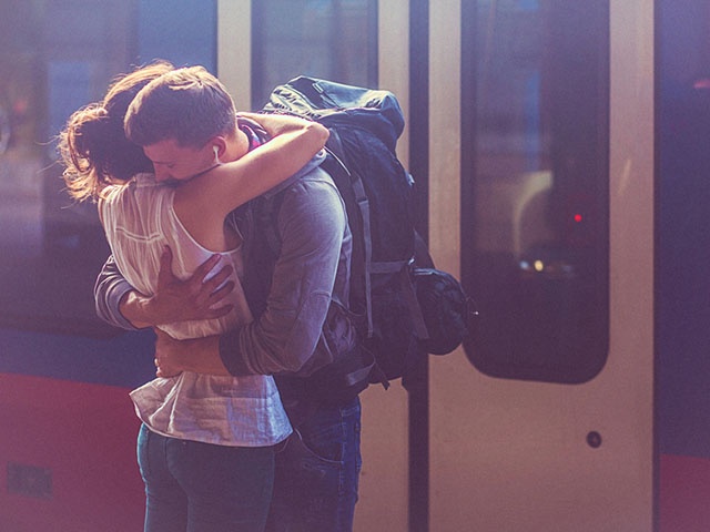 Portrait of woman and man embracing at the railway platform