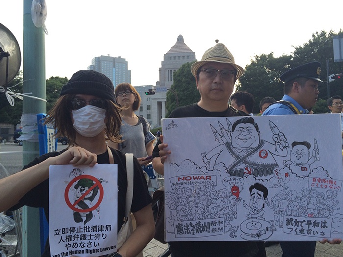 筆者が国会前デモしたときの様子（左が著者、右が中国人風刺漫画家の変態唐辛子さん）