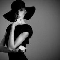 high fashion portrait of elegant woman in black and white hat and dress. Studio shot