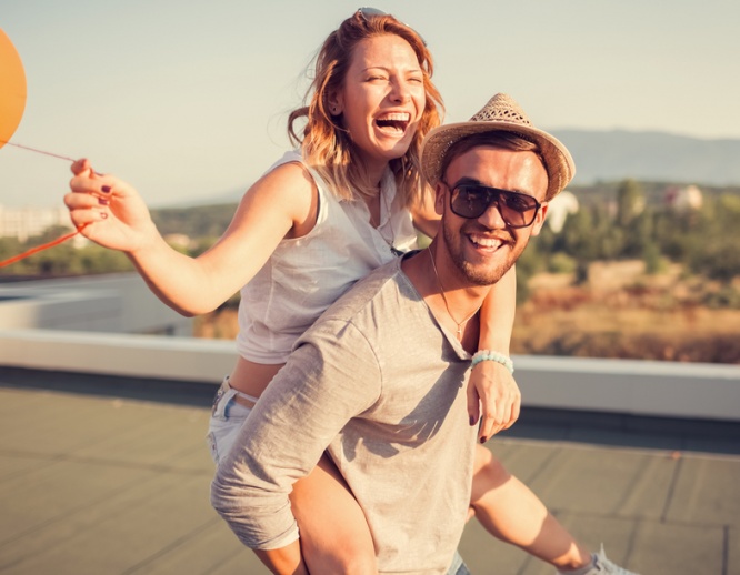 Friends piggyback on the rooftop